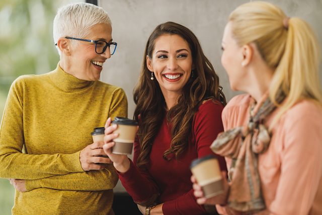 Three colleagues talking and laughing together during a break
