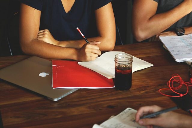 Notebook, laptop and pens on a meeting room table