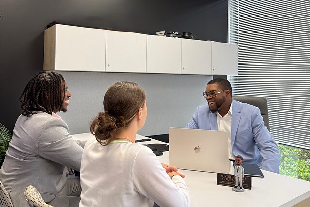 Channel Focus team members meeting with a colleague across an office desk