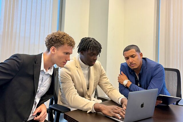 Three Channel Focus team members working through a task together on a laptop